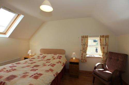 a bedroom with a bed and a chair and a window at John Joe's Self Catering in Blacklion