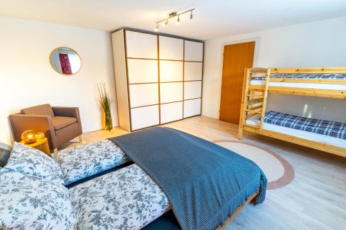 a bedroom with a bed and bunk beds at Charmantes Apartment mit grossem Garten .Kids4free. in Flims