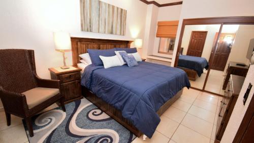 a bedroom with a bed and a chair and a mirror at Ground Floor Sonoran Sun 111-E - 1BR 1BA in Puerto Peñasco