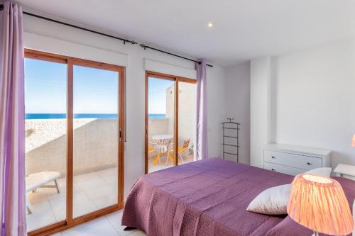 a bedroom with a bed and a balcony with the ocean at Altea Top Quality Duplex-home in Altea