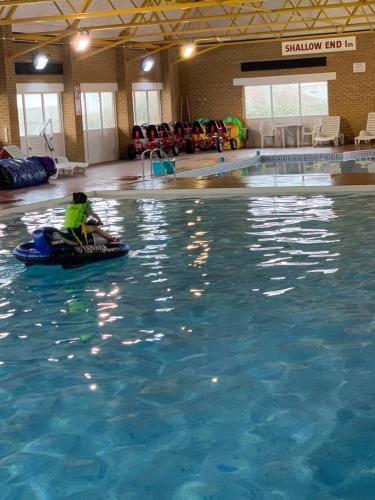 une personne à bord d'un radeau dans une piscine dans l'établissement Cosy Private Caravan Romney Sands Holiday Park, à New Romney