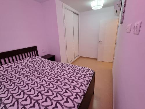 a bedroom with a bed with a black and white comforter at Pinar de GARRUCHA in Garrucha