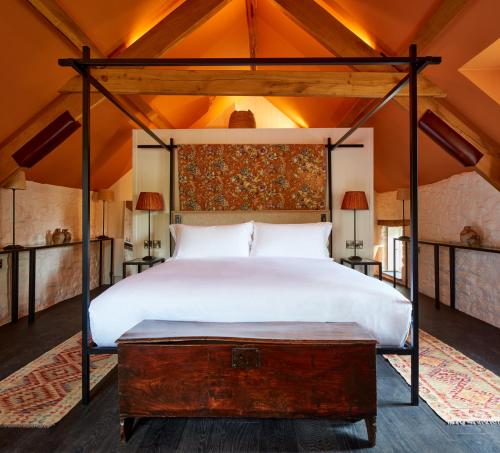 - une chambre avec un grand lit et une table en bois dans l'établissement Grove of Narberth, à Narberth