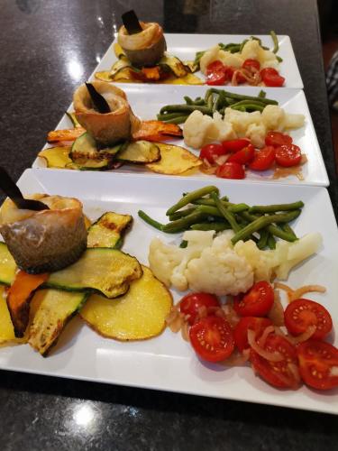 three white plates with different types of food on them at Casa Oliva borgo del Benessere Olistico in Bargni