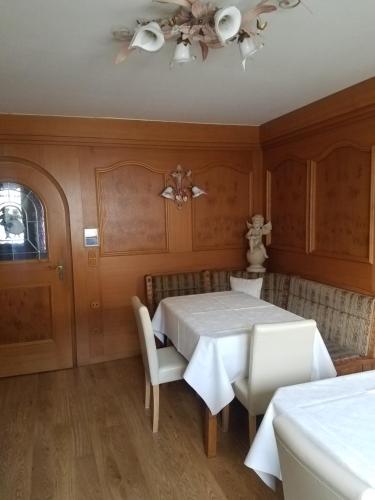 una sala da pranzo con tavolo e sedie bianchi di Gästehaus Fahringer a Walchsee