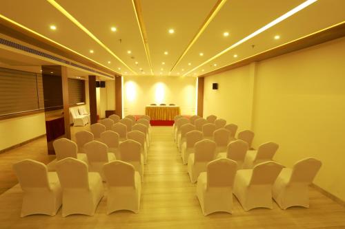 a conference room with white chairs and a table at Magnet Hotel in Kannur