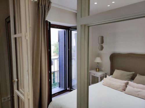 - une chambre avec un lit et une grande fenêtre dans l'établissement Apartamento Premium en el Centro de Sevilla, à Séville