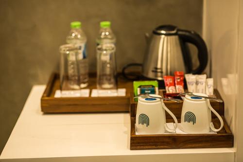 a table with two coffee mugs and a tea kettle at Green Acres Leisure Resort & Spa in Kandy