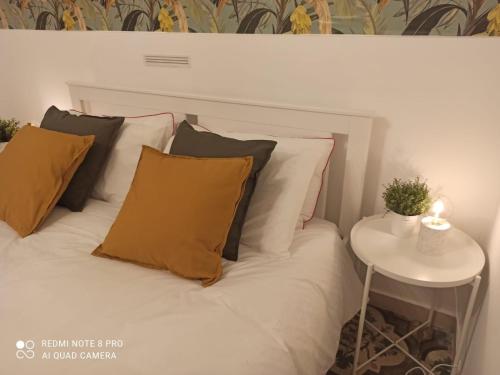 a bed with brown and white pillows and a table at Appartamento con cortile a 30 mt. dal mare in Bari