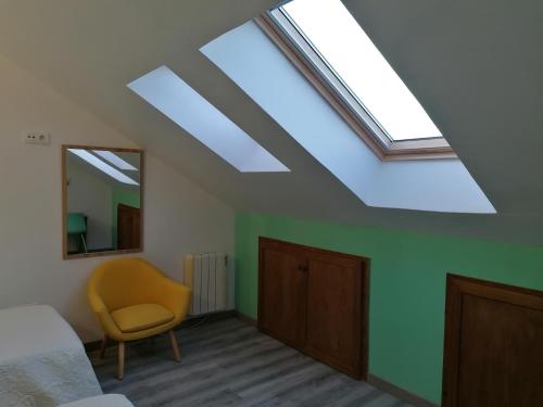 a bedroom with a skylight and a bed and a chair at Apartamento Turístico La Mies in Oreña