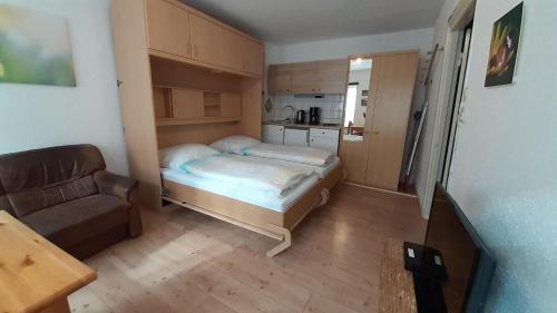 1 dormitorio pequeño con 1 cama y 1 sofá en 1-Zimmer-Apartment-1-im-1-Obergeschoss en Lübeck