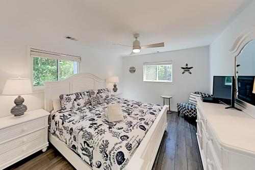 ein weißes Schlafzimmer mit einem Bett und einem TV in der Unterkunft Lawson Road 10 in Hilton Head Island