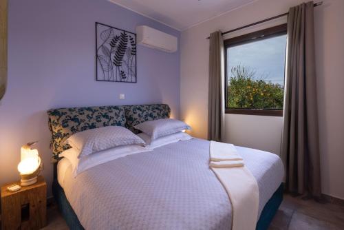a bedroom with a large bed and a window at Desa Green Homes in Ancient Epidavros