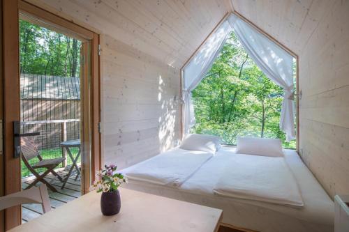 uma cama num quarto com uma janela em Kamp Koren Kobarid em Kobarid