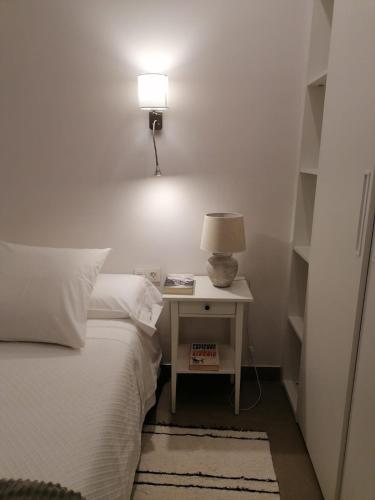 a bedroom with a bed and a nightstand with a lamp at Apartamentos MadreSelva in Fernán Pérez