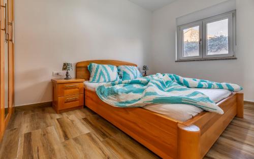 a bedroom with a wooden bed and a window at Medulinka apartments in Medulin