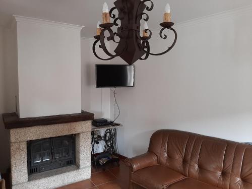 a living room with a couch and a fireplace at Melodia do Campo in Terras de Bouro