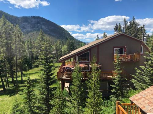 a large house with a deck in the woods at HI Banff Alpine Centre - Hostel in Banff