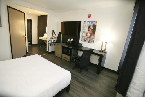 a hotel room with a bed and a desk with a computer at La Quinta by Wyndham Des Moines West Clive in Clive