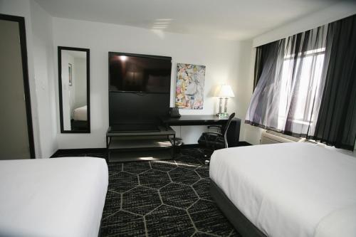 a hotel room with two beds and a desk at La Quinta by Wyndham Des Moines West Clive in Clive
