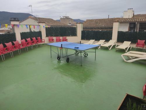 uma mesa de pingue-pongue numa piscina de água com cadeiras em Alberg SPRINT em Banyoles