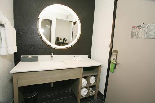 a bathroom with a sink and a mirror at La Quinta by Wyndham Des Moines West Clive in Clive