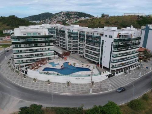 a large building with a pool in front of it at Le Bon Vivant - Praia Grande - Arraial do Cabo in Arraial do Cabo