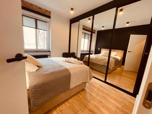 sypialnia z 2 łóżkami i dużym lustrem w obiekcie Apartamenty KTW Park Śląski w mieście Katowice
