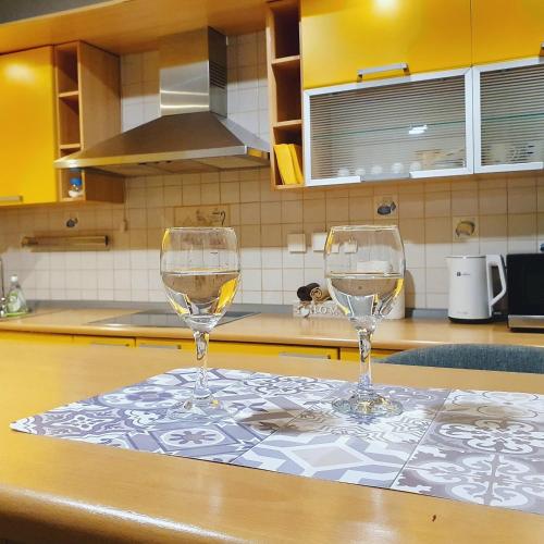 two wine glasses sitting on a table in a kitchen at Apartments Arna in Visoko