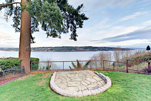 a stone fire pit in the grass next to a tree at Stones Way in Lake Forest Park