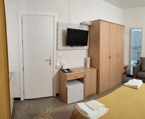 a room with a desk and a television in a room at Hotel Villa Costa in Celle Ligure