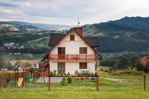 una casa in cima a una collina con le montagne sullo sfondo di Villa Apia a Piwniczna