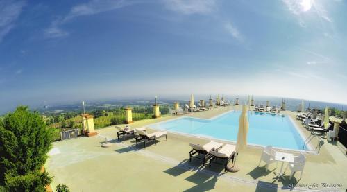 a large swimming pool with lounge chairs at Relais La Colombara Spa & Wellness in Travo