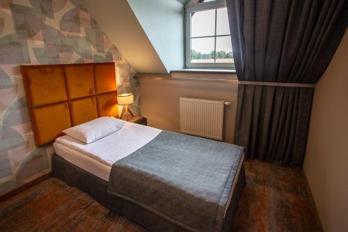 a small bedroom with a bed and a window at Hotel Styl 70 in Pszczyna