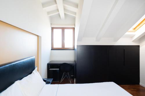 a bedroom with a large bed and a desk at SIRIOHotel in Dormelletto