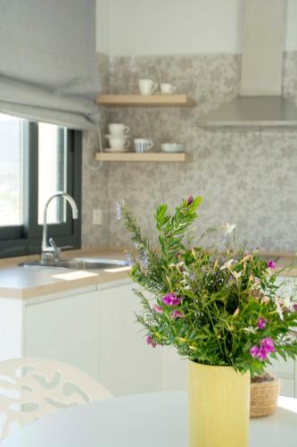 a yellow vase with flowers on a kitchen counter at Apartamentos MadreSelva in Fernán Pérez