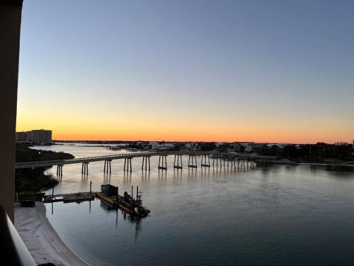 een uitzicht op een rivier met een pier bij zonsondergang bij Ole River Hideway, Orange Beach, Updated 2 Bedroom Waterfront Condo, Wind Drift in Orange Beach