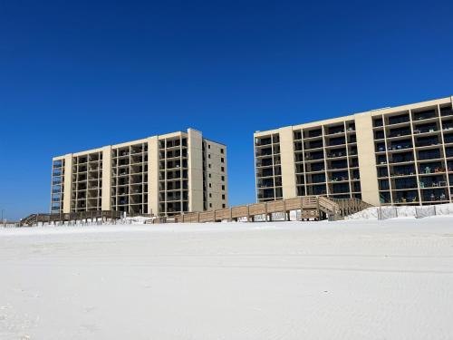 two tall buildings on the beach with snow at Ole River Hideway, Orange Beach, Updated 2 Bedroom Waterfront Condo, Wind Drift in Orange Beach