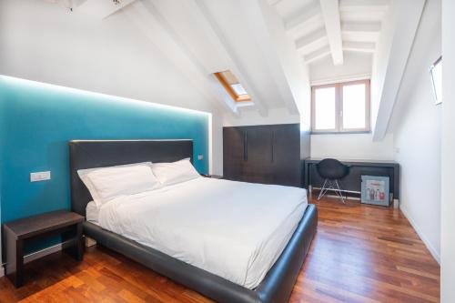 a bedroom with a bed and a blue wall at SIRIOHotel in Dormelletto