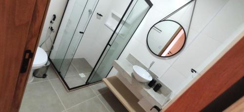 a bathroom with a mirror and a sink at Pé na areia Itacimirim in Camacari