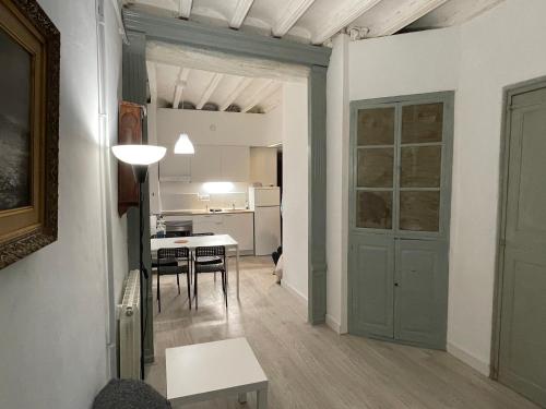 ein Wohnzimmer mit einer Tür und einem Tisch mit Stühlen in der Unterkunft Cal Mestre- Olot in Olot
