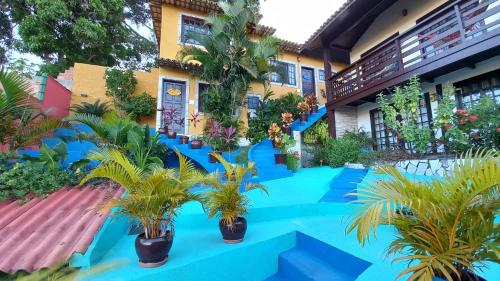 a resort with blue floors and palm trees in front of a building at Flats Tartaruga Búzios in Búzios