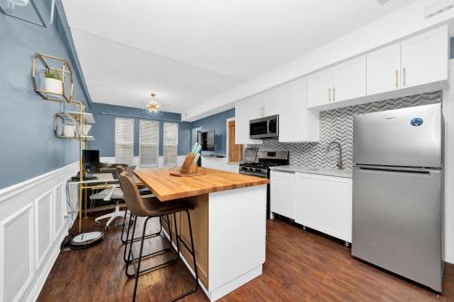 a kitchen with white cabinets and a wooden counter top at Modern 2 Bedroom in Avondale in Chicago