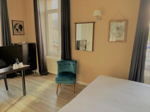 ein Schlafzimmer mit einem Bett, einem Stuhl und einem Spiegel in der Unterkunft Hôtel de Bretagne Dol centre ville - Hotel et Restaurant in Dol-de-Bretagne