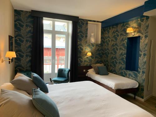 A bed or beds in a room at Hôtel de Bretagne Dol centre ville