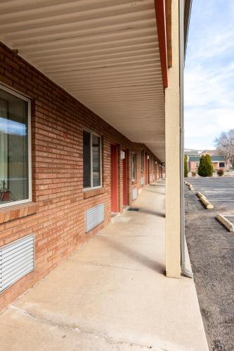 an empty walkway next to a brick building at Cedar Valley Inn in Cedar City