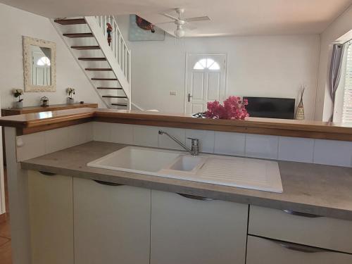 a kitchen with a sink and a staircase at VILLA STE MARTHE avec piscine, grande terrasse, jardin intime et citerne d'eau in Saint-François