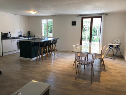 une cuisine et une salle à manger avec une table et des chaises dans l'établissement Maison au calme avec parking en petite Camargue, à Beauvoisin