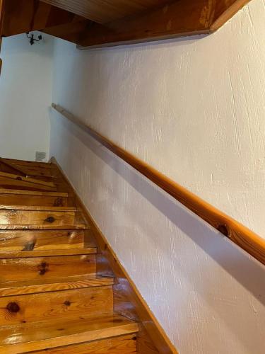 an empty room with wooden stairs and a white wall at La Casita de la Sierra Cercedilla in Cercedilla