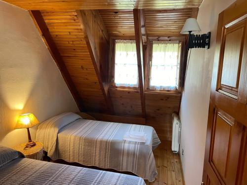 a bedroom with two beds in a wooden cabin at La Casita de la Sierra Cercedilla in Cercedilla